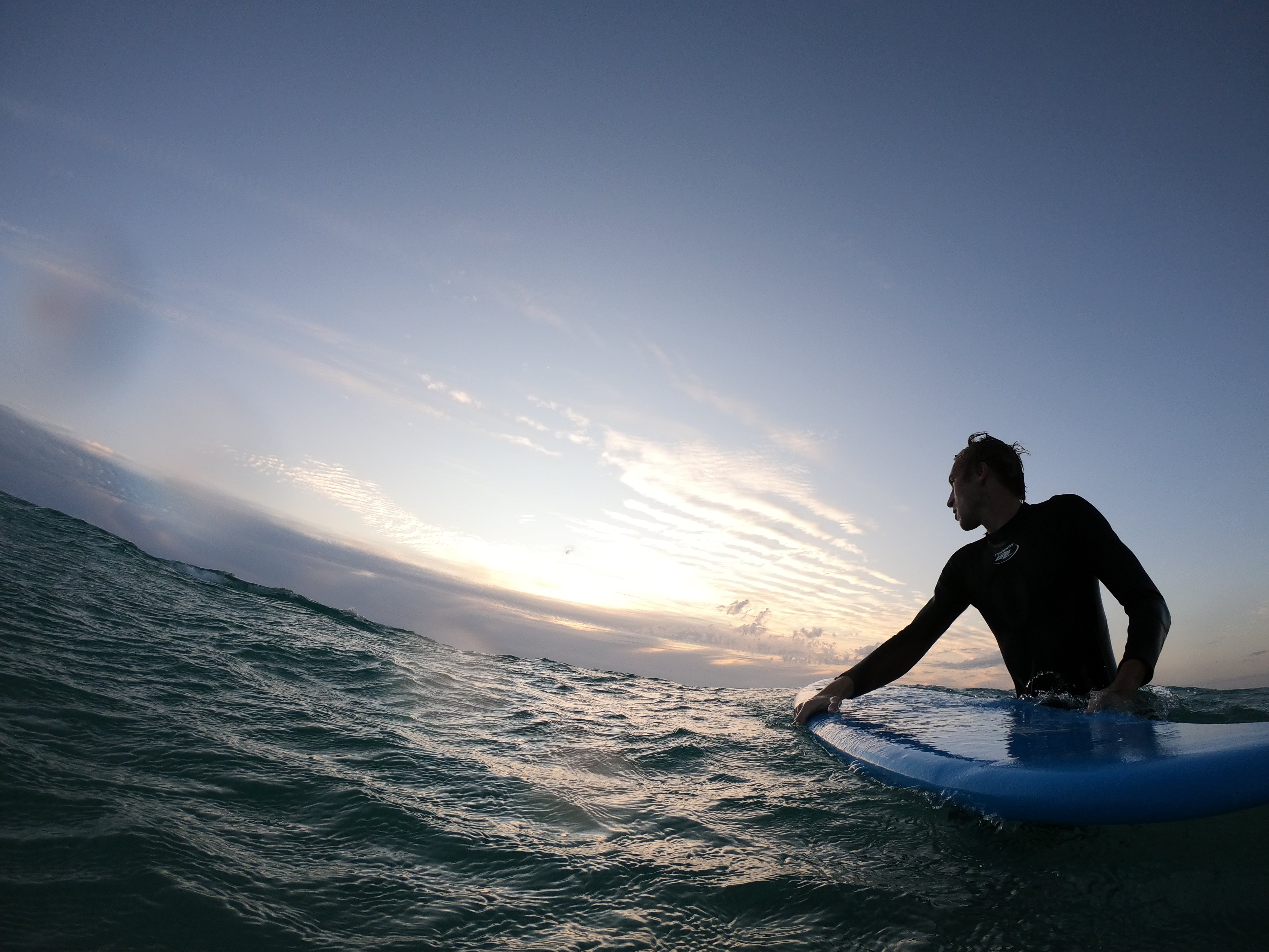 files/person-standing-in-wavy-water-holding-a-surfboard.jpg